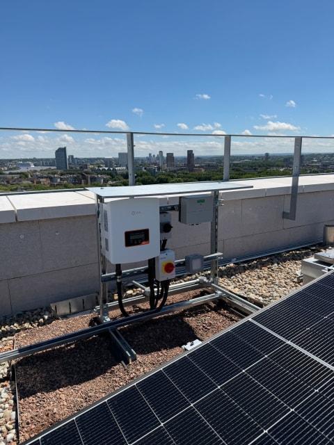 Solis solar inverter on a green-roof mounting frame in Canada Water, London, with the Canary Wharf skyline behind.