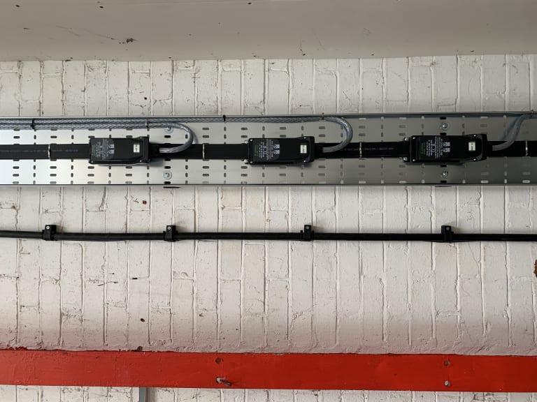 Wieland Podis flat cable system with four tap-off modules installed at high level inside Route One warehouse, Acton Turville