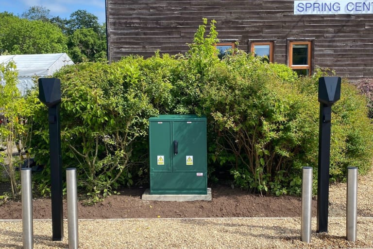 GRP electrical cabinet flanked by Easee charger pedestals at The Hospice of St Francis healthcare facility in Hertfordshire.