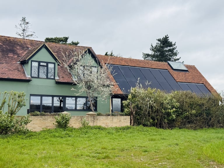 Detached period cottage in Broxted, Essex, showing completed in-roof solar panels flush-mounted in the red clay tile roof.