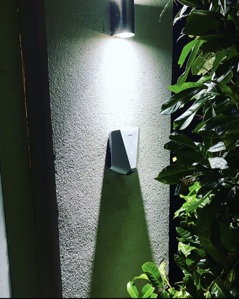 An Easee home charger installed on a house wall in the evening