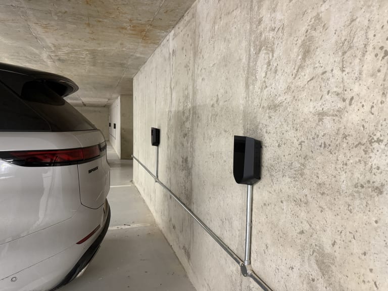 Two Easee EV chargers mounted in the underground car park at Lincoln Court, Weybridge, beside a parked Range Rover