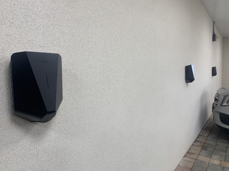 Two Easee One EV chargers installed on a wall in the car park at Wickliffe Court residential development, Hendon