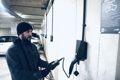 An evon engineer running diagnostic tests on a wall mounted EV charger