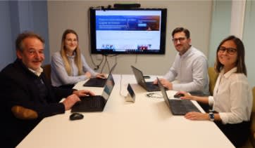 4 personnes assises autour d'un bureau, devant leur ordinateur.