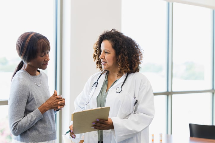 Une médecin en blouse expliquant un diagnostic à une patiente