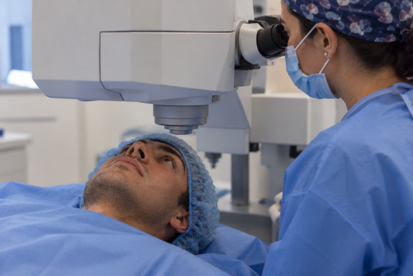 homme dans une table d'opération avec un laser et la chirurgienne pour l'opérer de l'astigmatisme