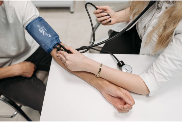 Hypertension : Symptômes et traitements. Une soignante prend la tension d'un patient.