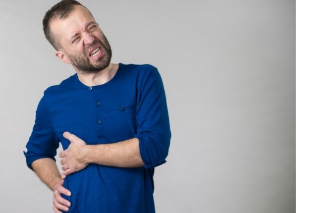 douleurs Douleur intercostale : Symptômes et traitements. Un homme se tient la côte de douleur. 