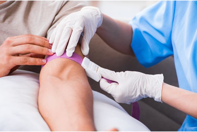 Anémie : préparation à une prise de sang. Un ou soignante pose un garrot.