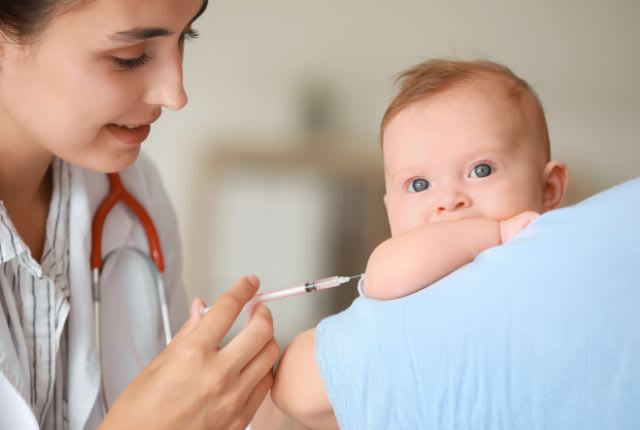 Bronchiolite : quand vacciner en 2025 ? Image d'une infirmière avec une seringue dans la main devant un nourrisson..
