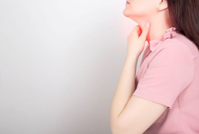 Femme portant sa main à son cou