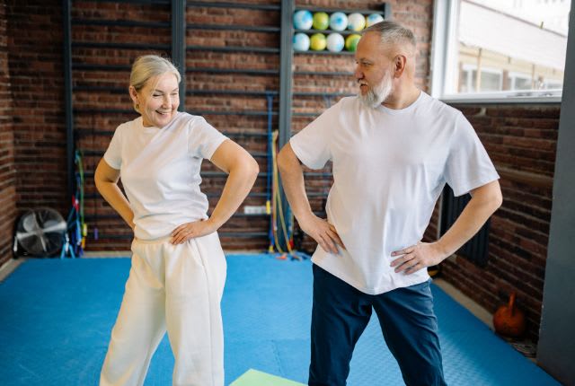 Coxarthrose ou arthrose de la hanche. Une femme et un homme d'âge mûr pratiquent gym douce et rotation de bassin.