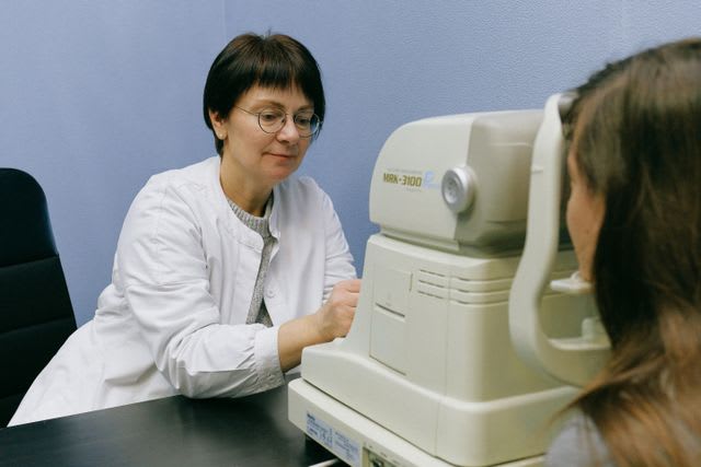 Photo d’une professionnelle de santé réalisant un examen ophtalmologique sur une patiente à l’aide d’un appareil de mesure de la vision.