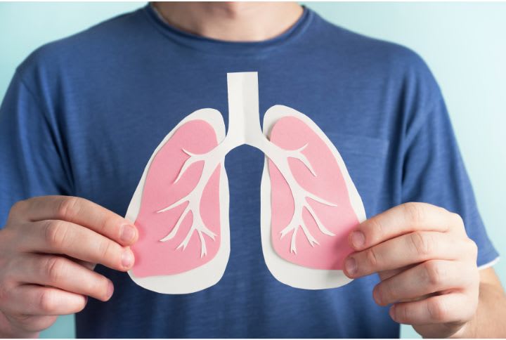 Double pneumonie ou pneumopathie bilatérale : un homme porte à la hauteur de son thorax, un schéma montrant deux poumons.