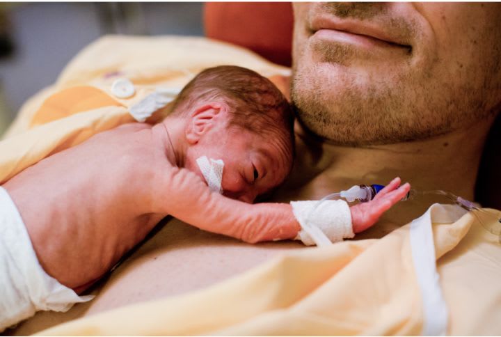 Bébé prématuré sur la poitrine de son papa.