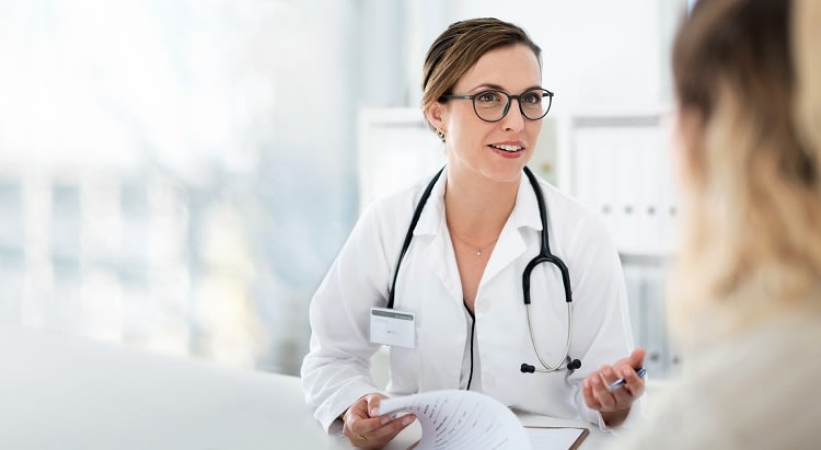 Une médecin souriante expliquant un compte rendu médical à une patiente