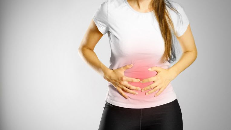 Endométriose : une femme se tient le ventre de douleur.