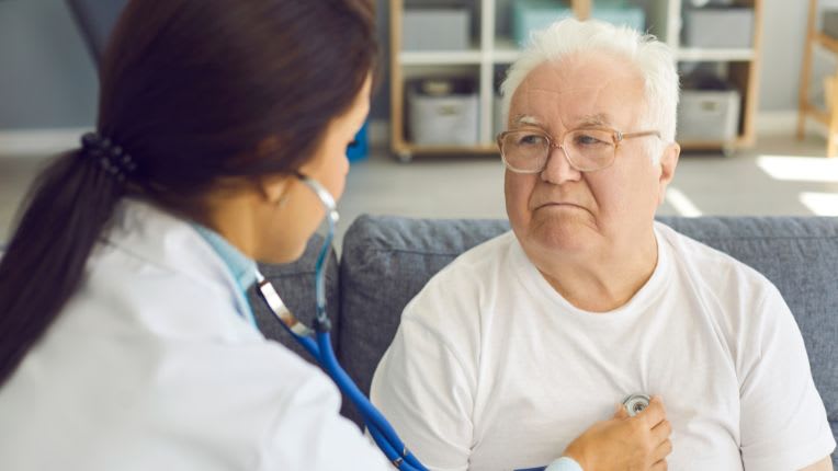 Cancer du cœur : une professionnelle de santé ausculte un homme âgé.