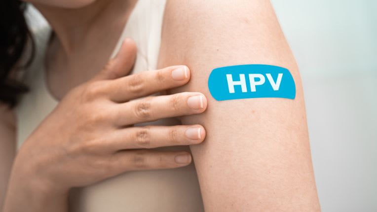Cancer du col de l’utérus : semaine européenne de prévention. Une jeune femme porte un pansement bleu avec la mention HPV, sur son bras, après une vaccination contre le papillomavirus humain.