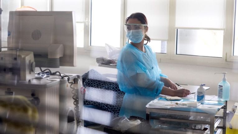 Deuxième avis médical. Patients internationaux ELSAN. Image d'une soignante en masque et blouse bleus.