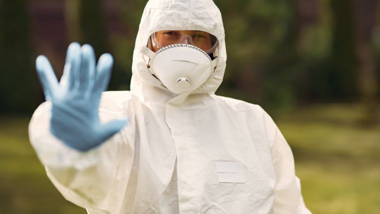 Virus Ebola. Une soignante en combinaison blanche complète de protection, masque et gants.