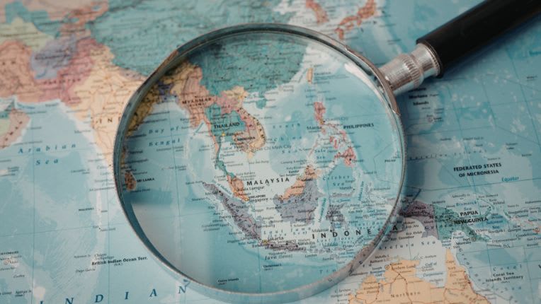 Vaccin contre l'encéphalite japonaise. Image d'une mappemonde montrant l'Asie et la partie ouest du Pacifique. Sur cette carte est posée une loupe au niveau des pays de l'Asie du sud-est.