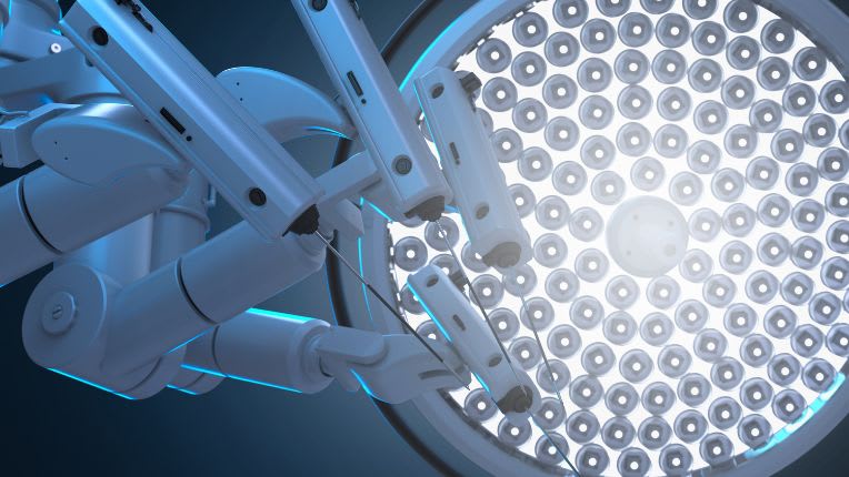 Opération de la bouche par robot à Montauban. Vue des bras d'un robot chirurgical sous la lumière d'une lampe de salle d'opération.
