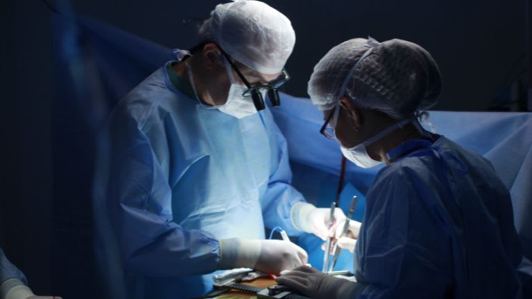 Opération du rectum par robot à Montauban. Image de chirurgien et chirurgienne dans une salle d'opération.