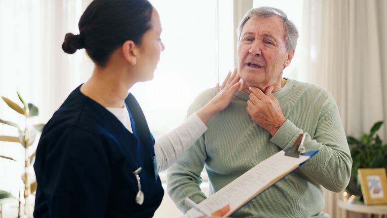 Des technologies médicales de pointe à Valenciennes. Une soignante inspecte la gorge d'un patient âgé qui se tient le cou.