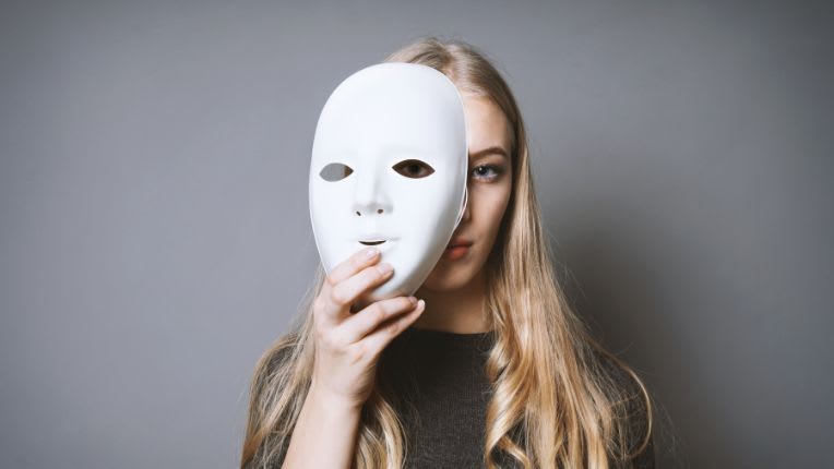 prosopagnosie. Image d'une femme cachée derrière un masque blanc sans expression non identifiable.