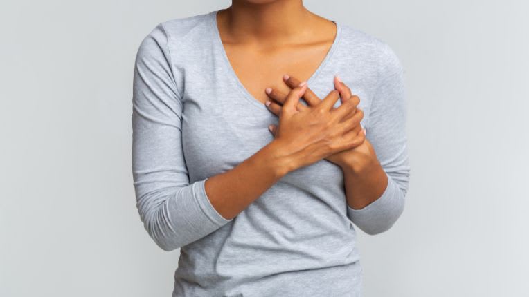 Santé des femmes : les femmes concernées par les maladies cardio-vasculaires. Image d'une femme dont on ne voit que le tronc et qui pose ses mains au-dessus de son sein gauche.