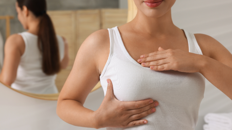 Autopalpation du sein : une femme place sa main sous son sein droit.