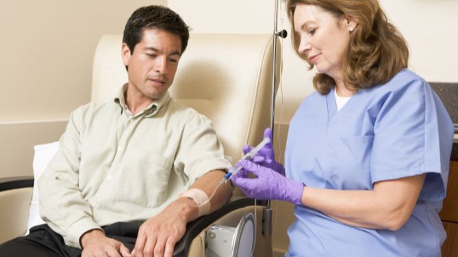 Infirmière : pratique avancée, IPA, en cancérologie : une infirmière injecte un traitement à un patient.