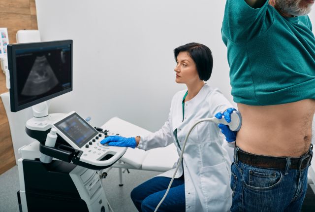 Quel est le meilleur examen pour les reins ? Image d'un patient chemise levée pour pendant qu'une soignante examine ses reins à l'échographie.