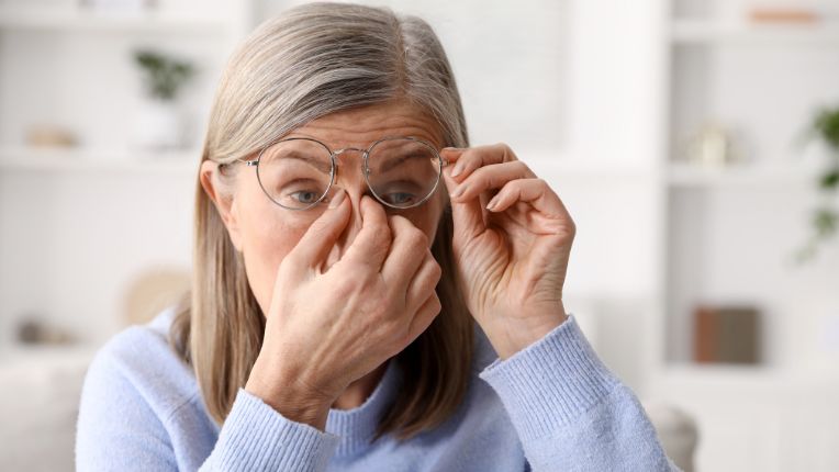 Santé des femmes. Asthénie. Image d'une femme qui se pince le nez de fatigue, en soulevant ses lunettes.