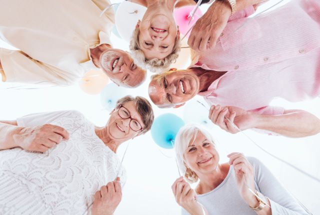Semaine bleue 2025 pour les séniors. Plusieurs personnes âgées joyeuses et actives forment un cercle vu d'en bas, avec un ballon bleu.