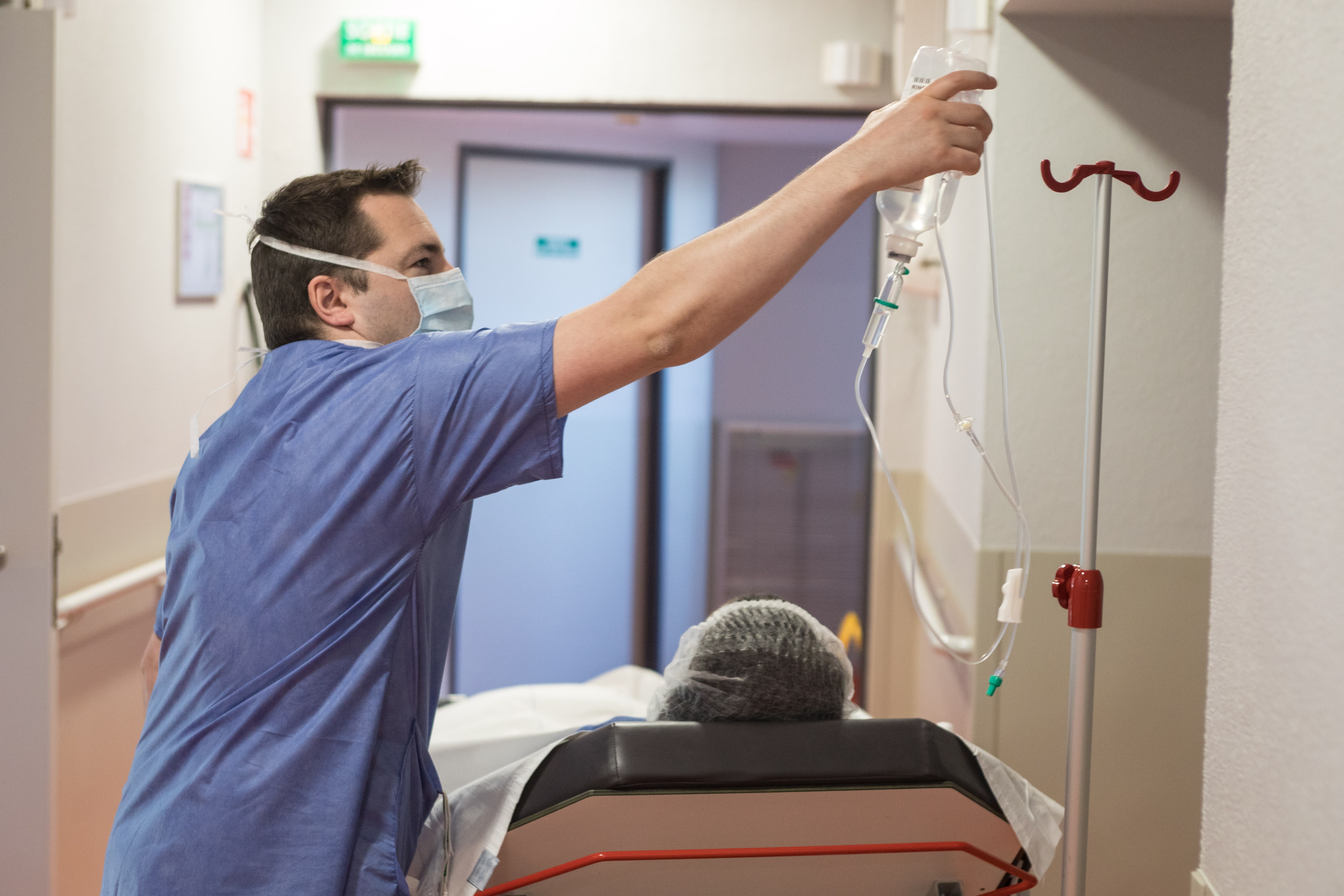 Infirmier qui soigne un patient allongé sur un brancard
