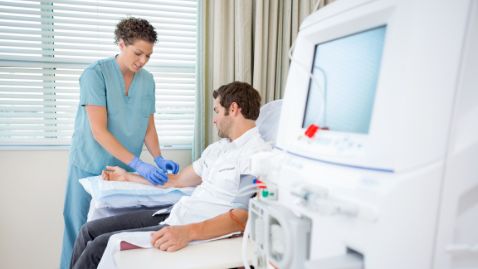 Infirmière en dialyse. Une infirmière prépare un patient pour une dialyse rénale.