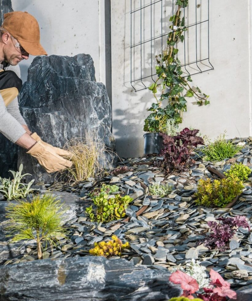 Caucasian Professional Landscaping Gardener in His 40s Finishing New Residential Garden Caucasian Professional Landscaping Gardener in His 40s Finishing New Residential Garden