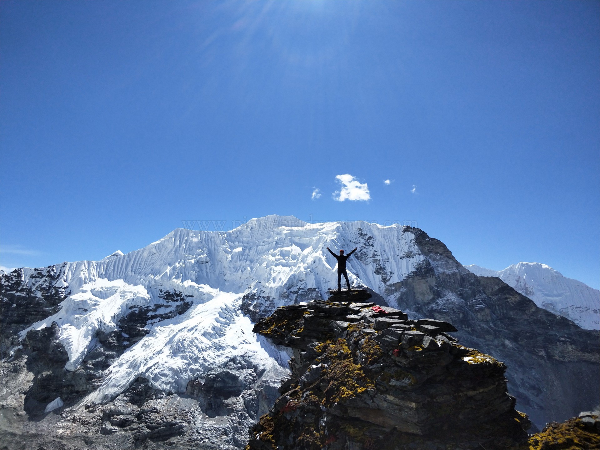 Climber standing on the summit of Island Peak (Imja Tse) at 6,189m with panoramic views of Mount Everest, Lhotse, and Ama Dablam in the Nepal Himalayas