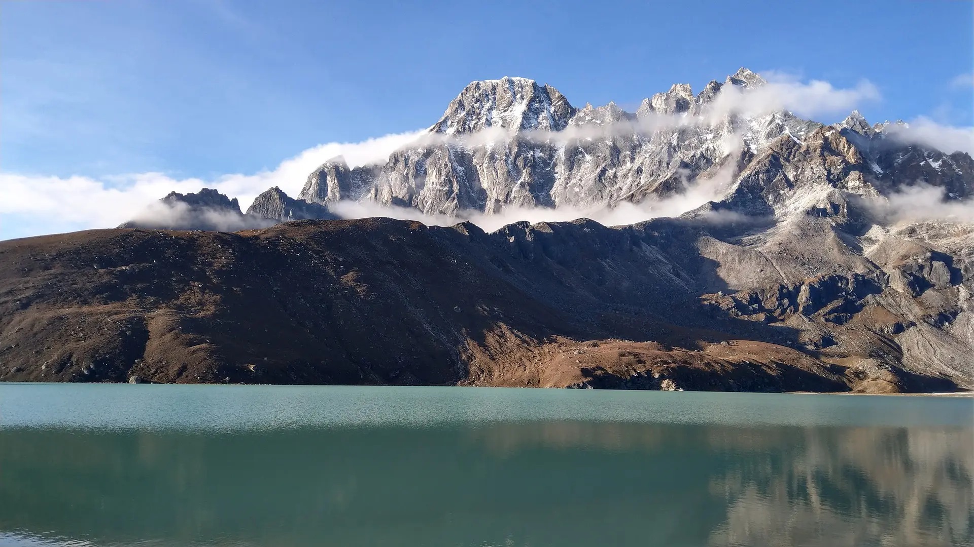 Turquoise Gokyo Lake surrounded by snow-capped Himalayan peaks in Nepal, on the Gokyo Lakes Trek .