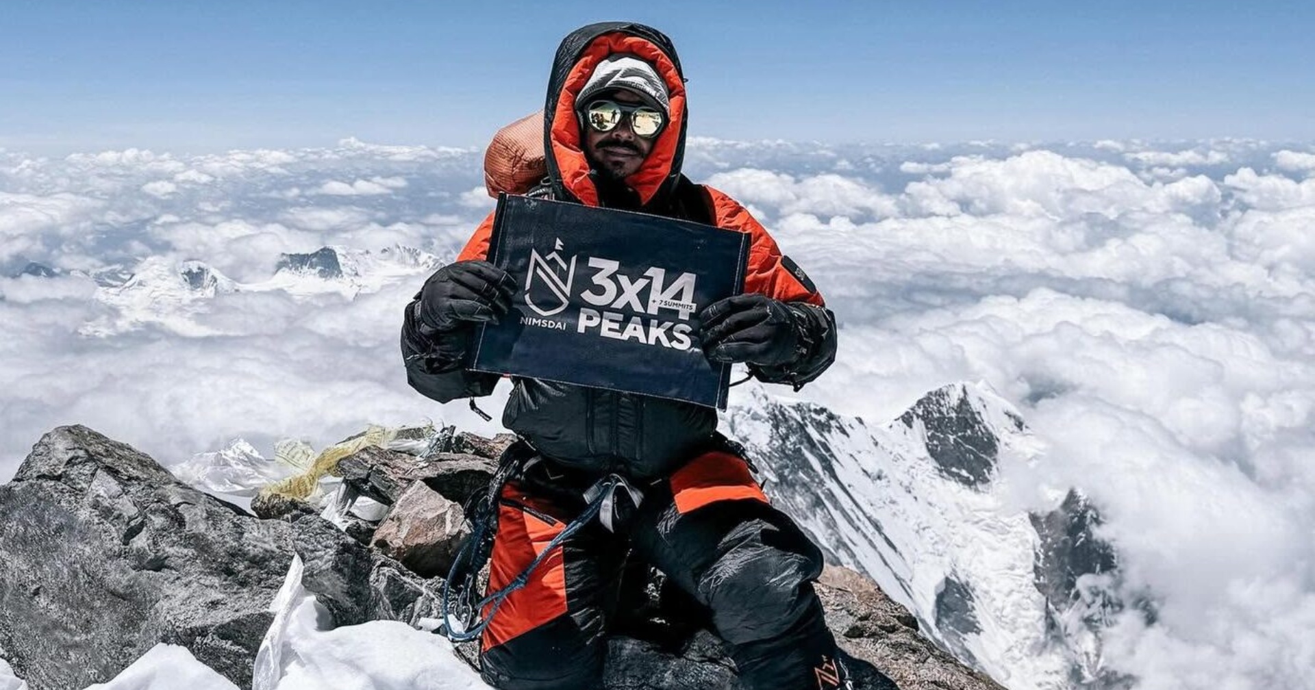 World-renowned Nepali mountaineer Nirmal "Nimsdai" Purja holding a sign celebrating his historic mountaineering achievements.