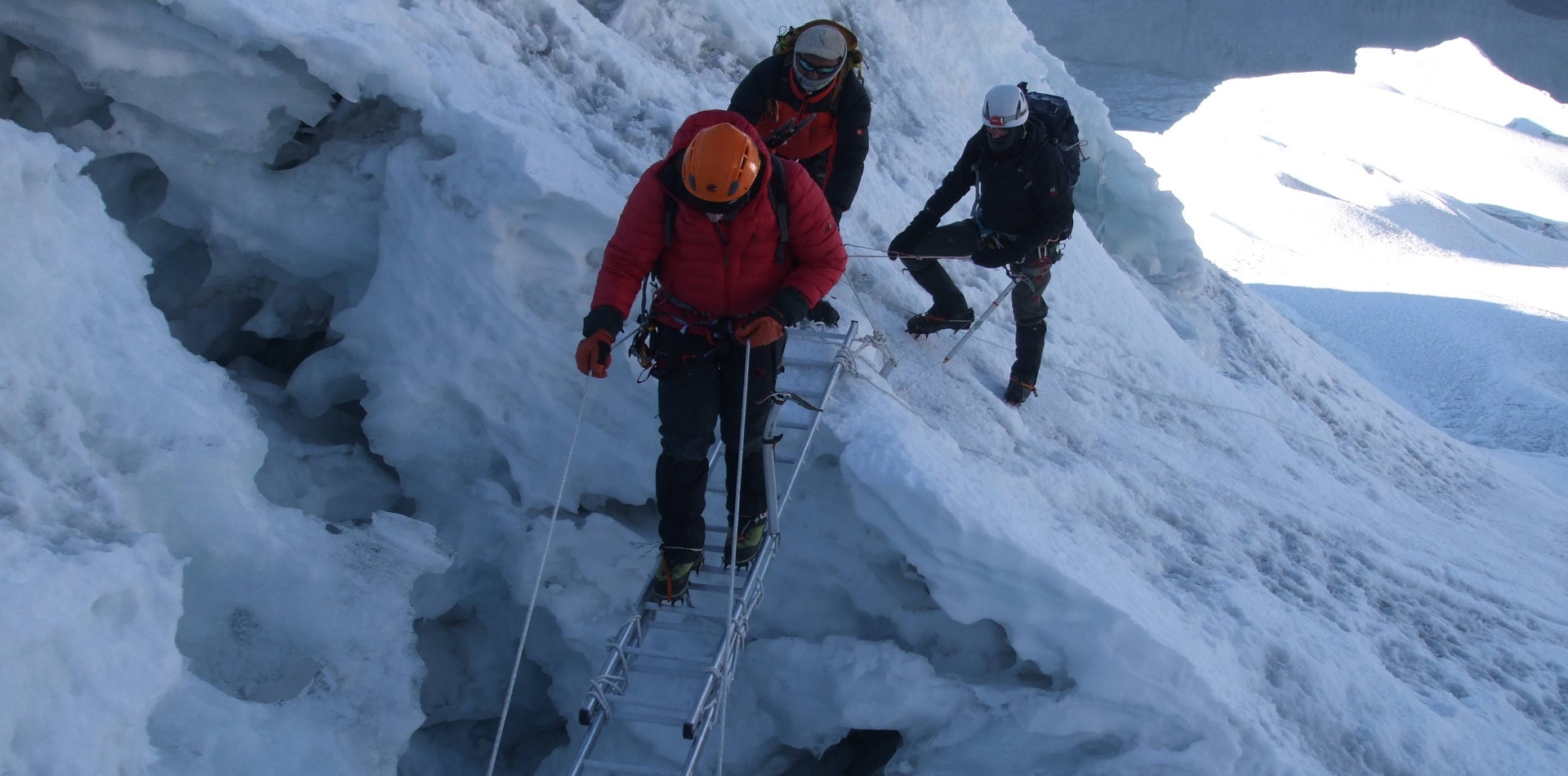 A roped team crossing a crevassed section of the glacier below Island Peak's headwall