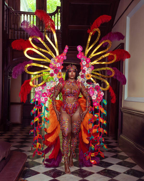 Woman in Ebony monokini with large floral and feathered backpack wings at Yard Mas Carnival for Jamaica Carnival 2026