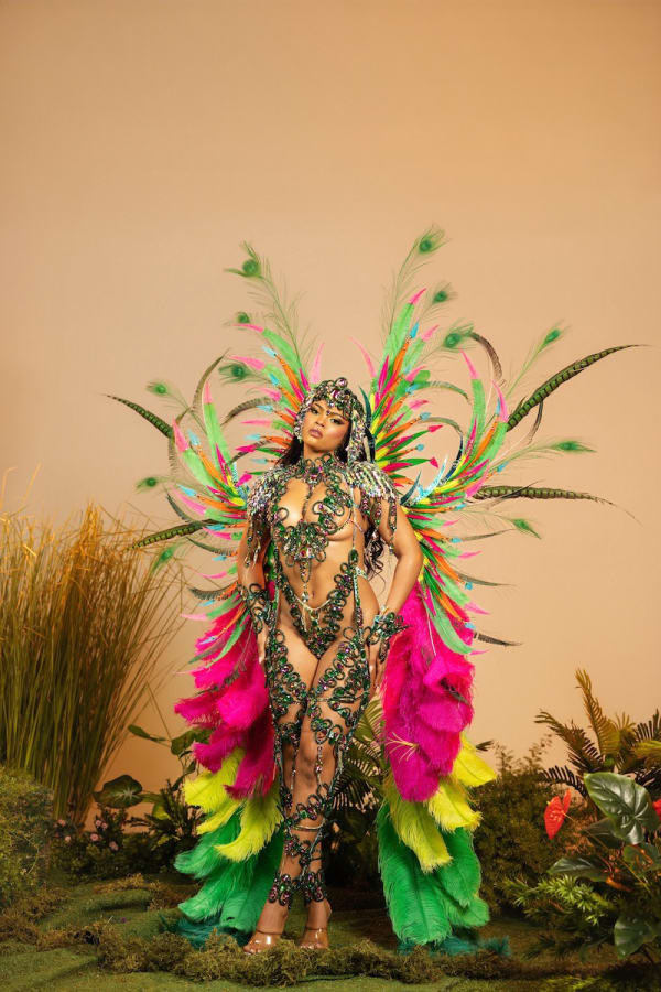 Female carnival dancer in Yuma Seduction section wearing colorful feathered backpack wings, beaded bikini, Hardline tiara and leg pieces at Trinidad Carnival 2027