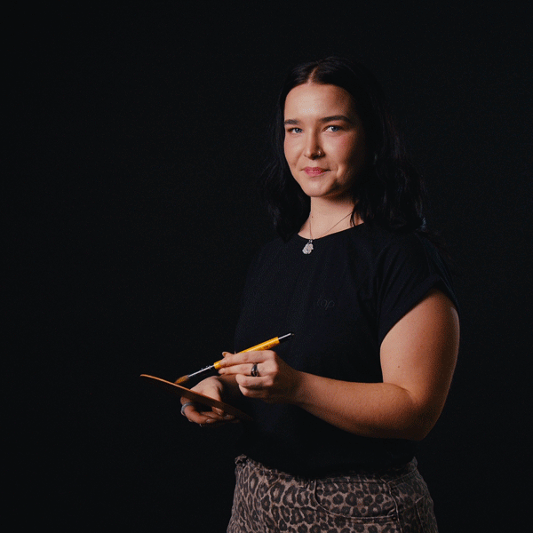 Laura Niemeier malt mit einem Pinsel in einem Videostudio