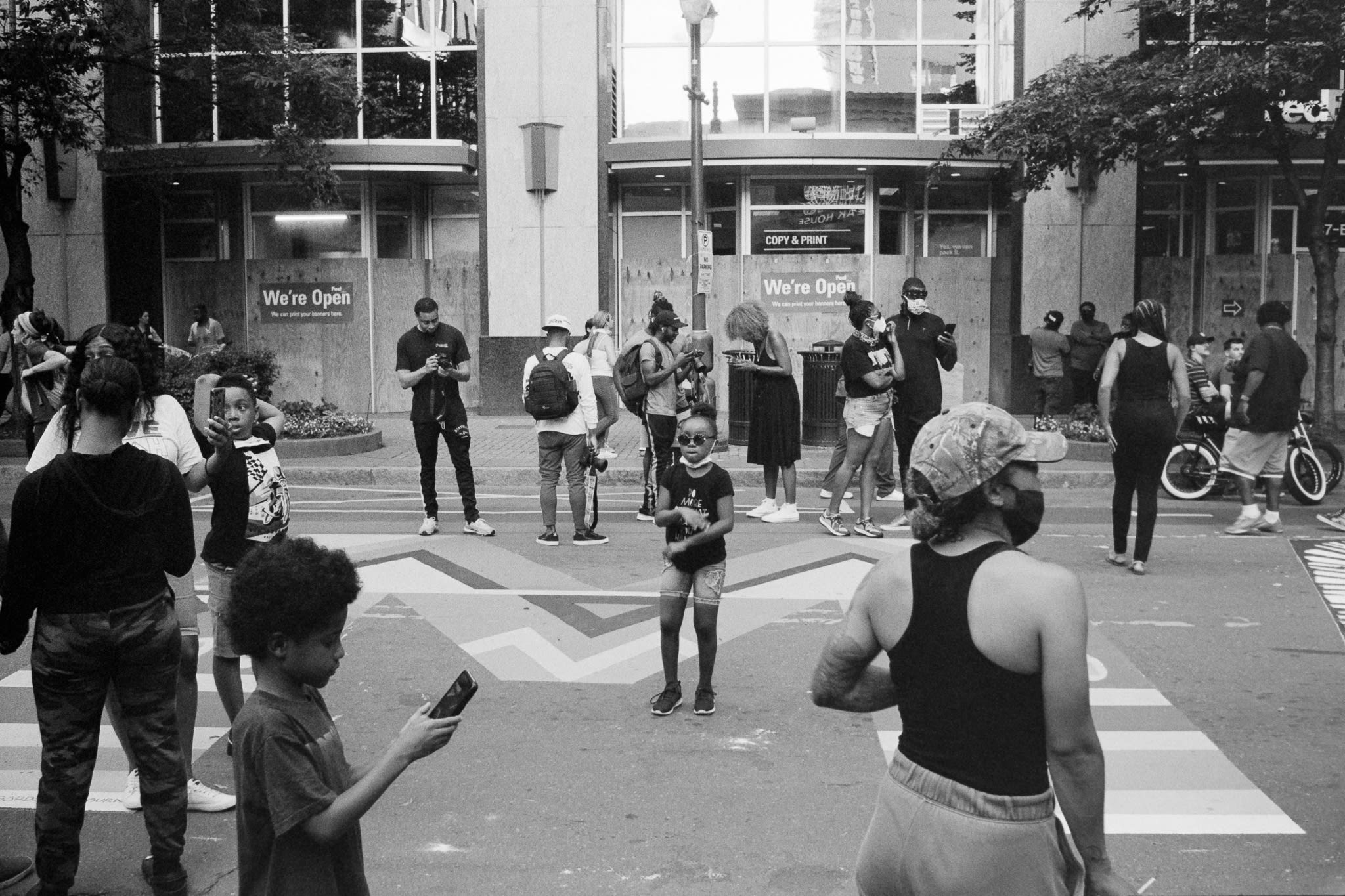 little girl dancing in a crowd viewing black lives matter mural