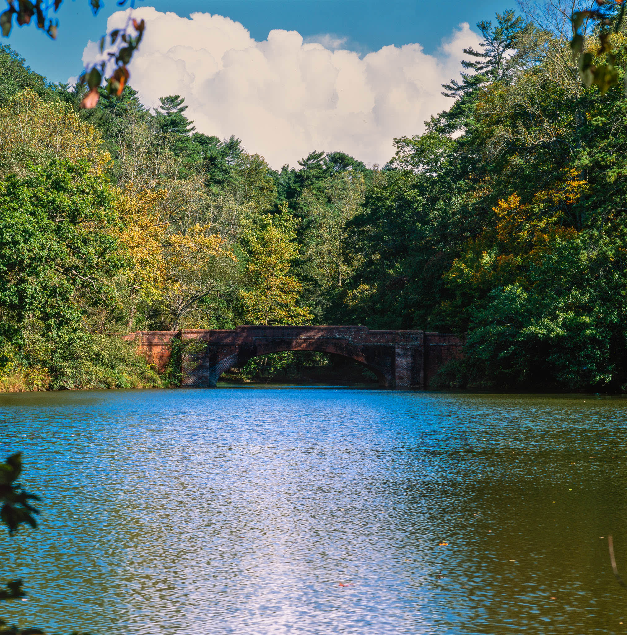 brick bridge crossing a pond