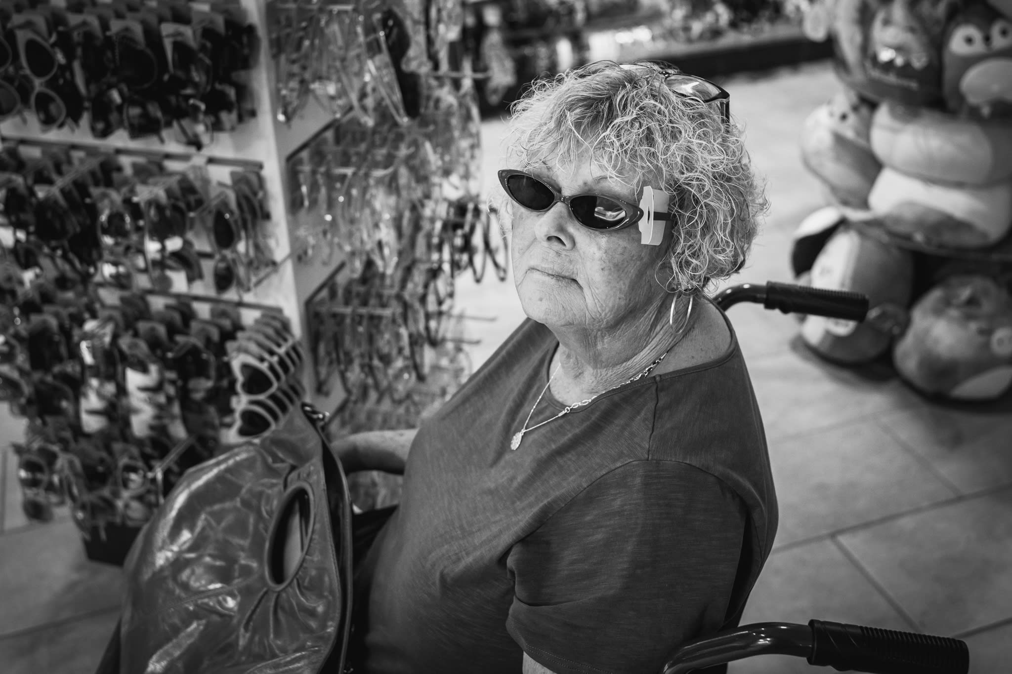 woman in wheelchair trying on sunglasses that are too small